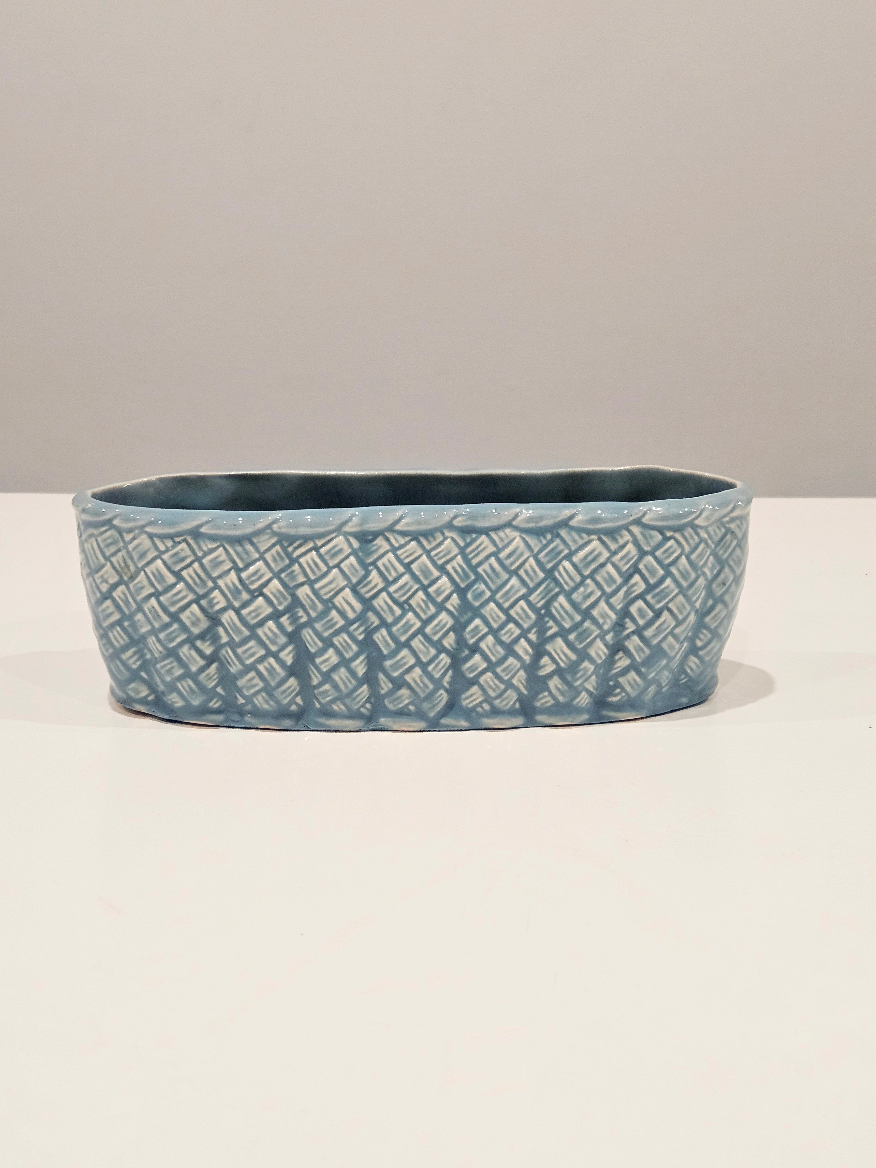 Blue ceramic table centrepiece vase with textured pattern on a white background