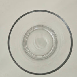 Top down view of a clear cylindrical glass vase on a white background