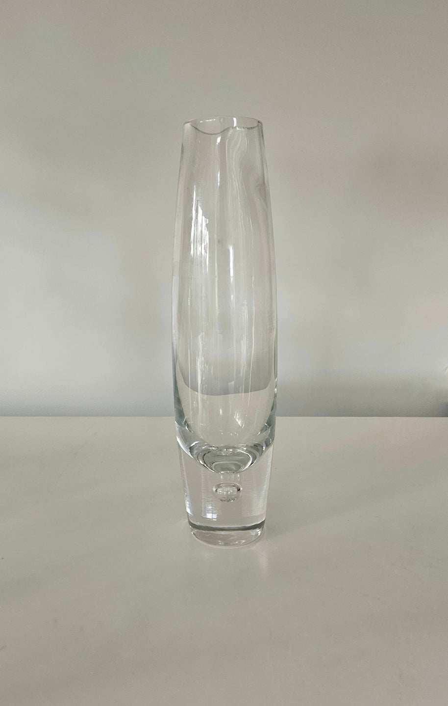 Clear glass vase on a white surface with a white background