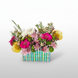 Colourful flower arrangement in a basket on a white background