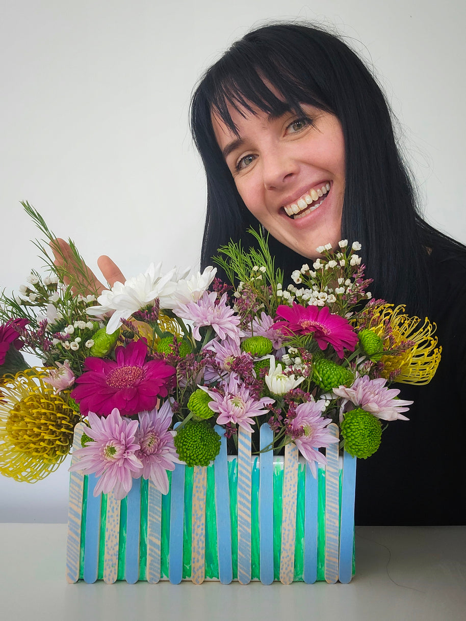 Whimsy and Woe Florist behind a kids craft flower arrangement with a white background