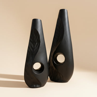 Two black ceramic wedges with textured design on a white background