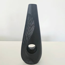 Black ceramic vase with a textured surface on a white background