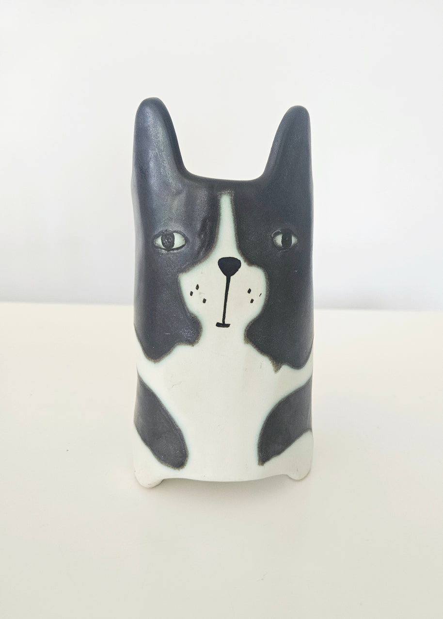 Ceramic dog-shaped pot with black and white design on a light background