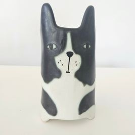 Ceramic dog-shaped pot with black and white design on a light background