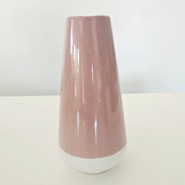 Pink and white ceramic vase on a white surface with a white background