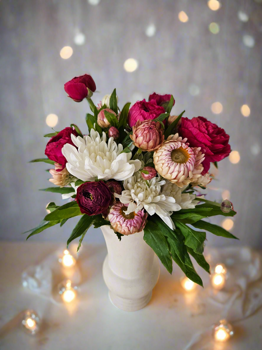 Bouquet of flowers in a white vase with a soft, blurred background