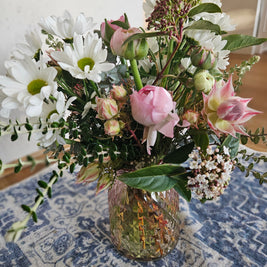 Bouquet of pink and white flowers on a patterned fabric background