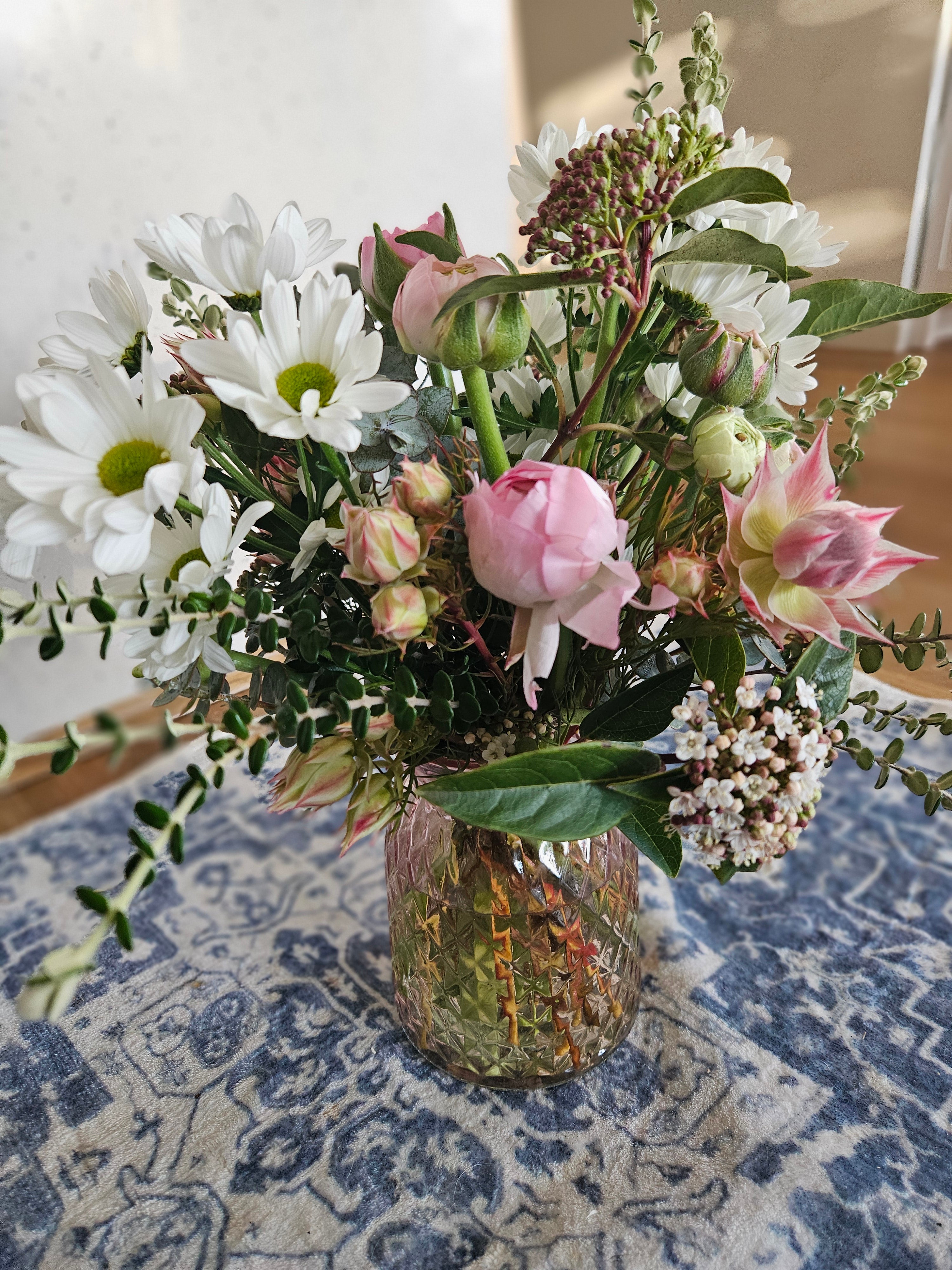 Bouquet of pink and white flowers on a patterned fabric background