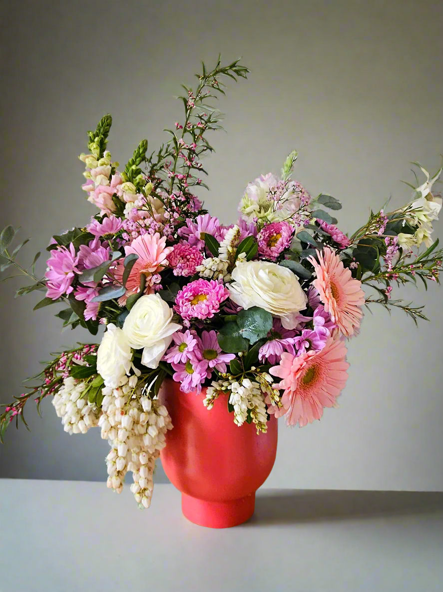 Bouquet of flowers in a peach pot on a neutral background
