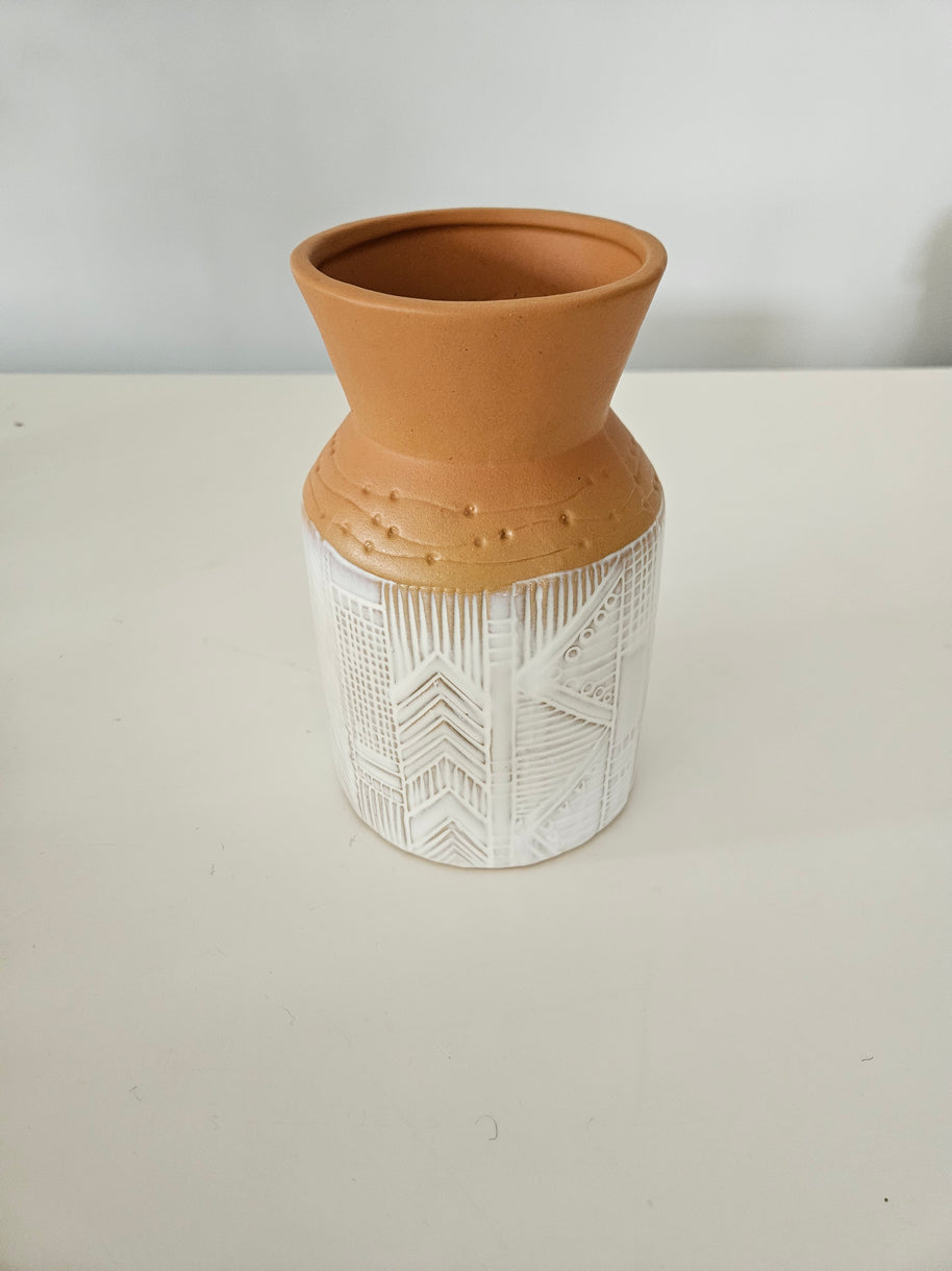 Decorative vase with terracotta base and white textured top on a light background