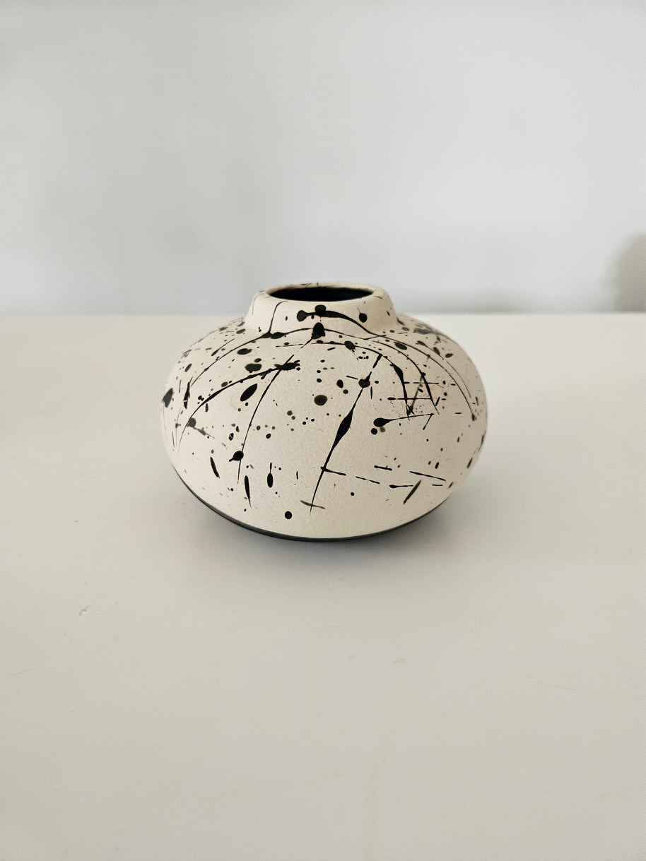 Black and white ceramic vase with black paint splatter design