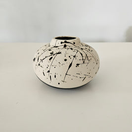 Black and white ceramic vase with black paint splatter design