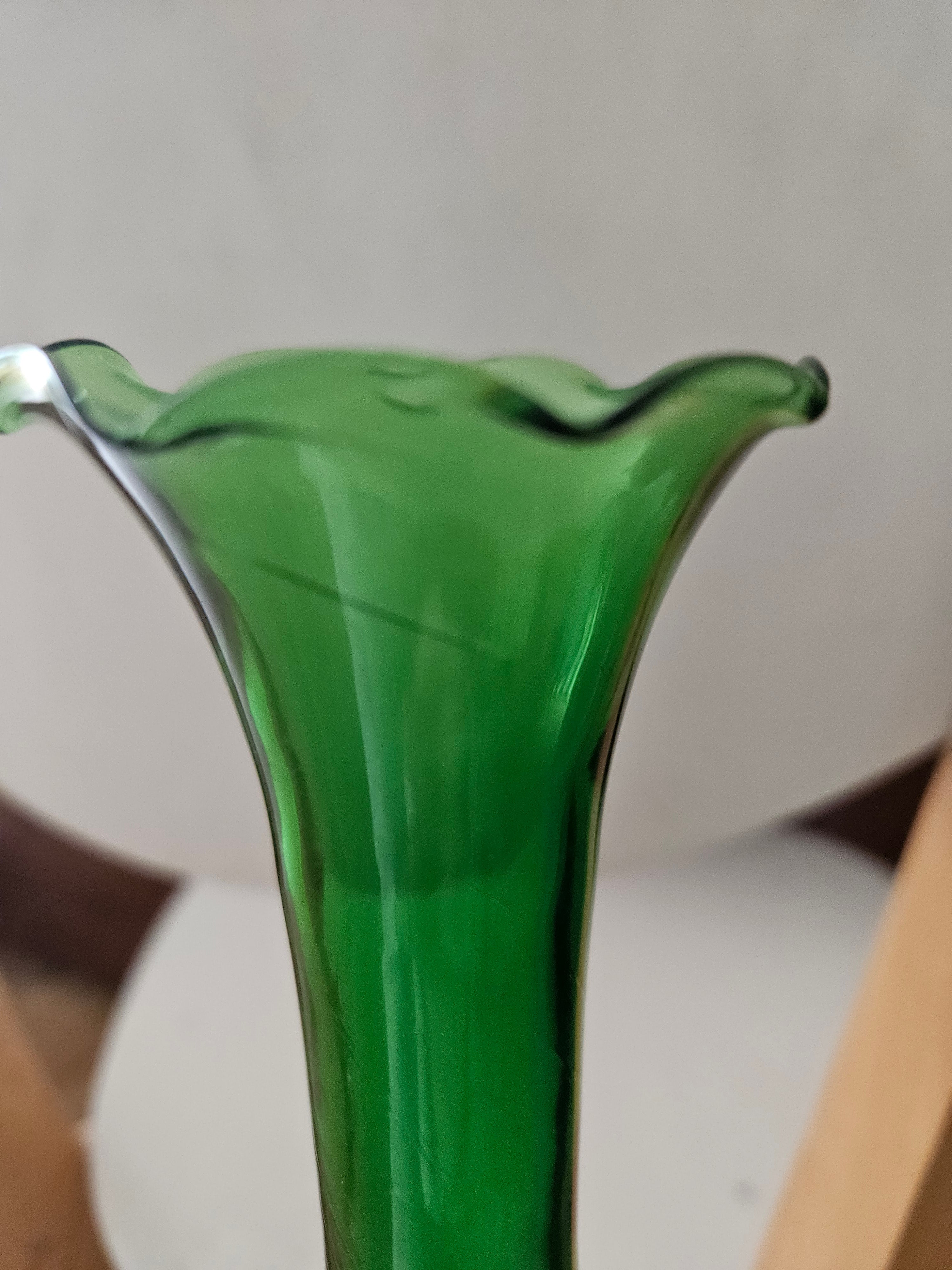Close-up of a green glass vase with a blurred background