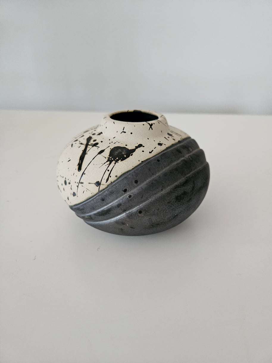 Black and white ceramic vase with black paint splashes
