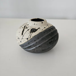 Black and white ceramic vase with black paint splashes