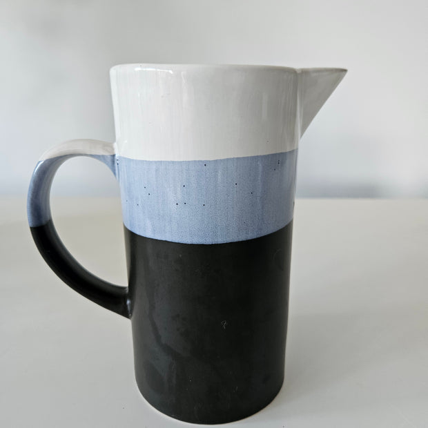 Black and white ceramic jug on a light grey background