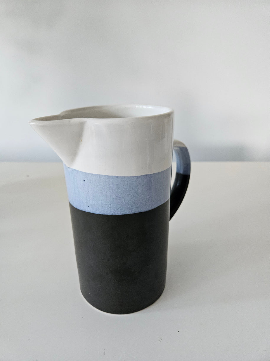 Blue and white striped jug on a white background