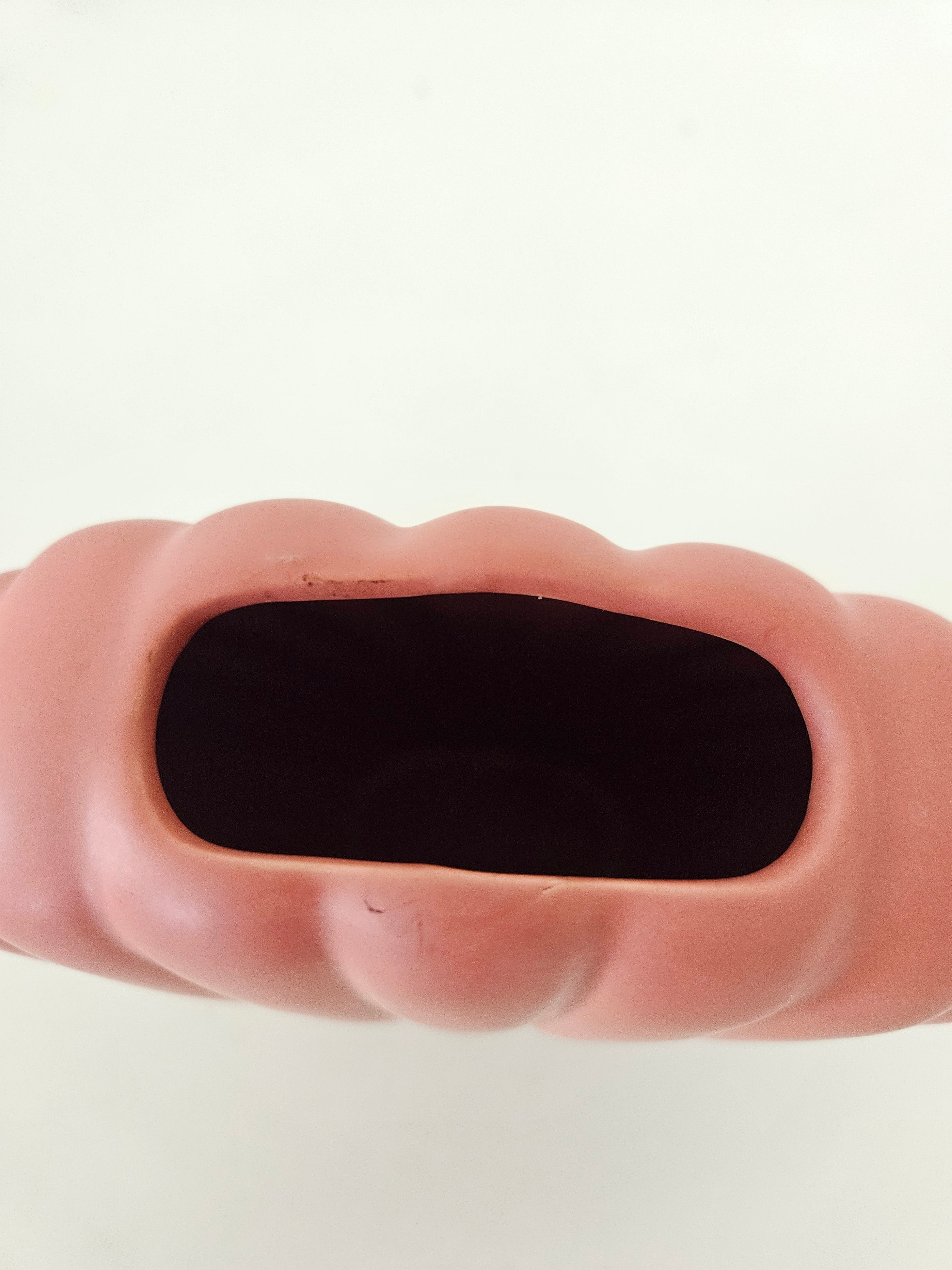 Top down view of a peach ceramic shell vase