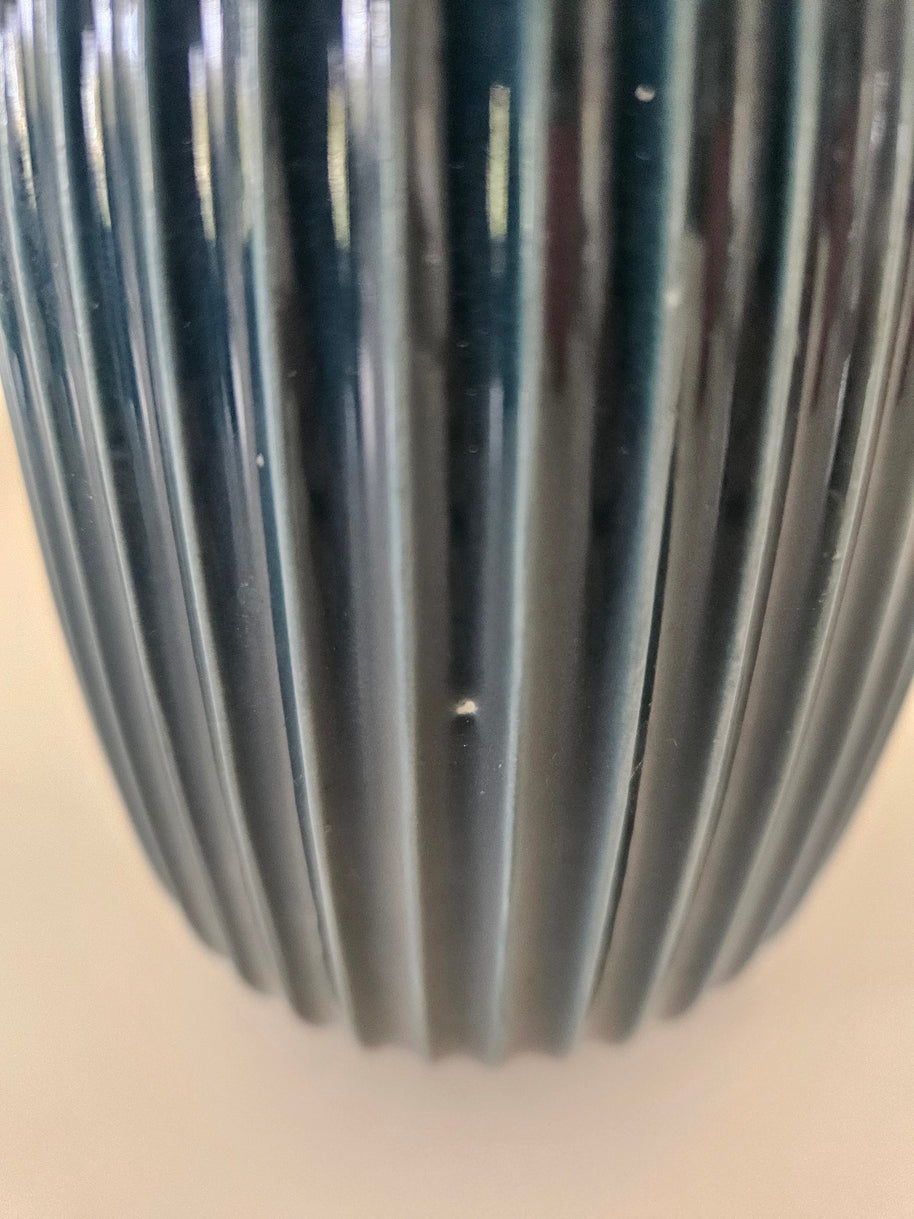 Close up of scratches on a blue ceramic vase