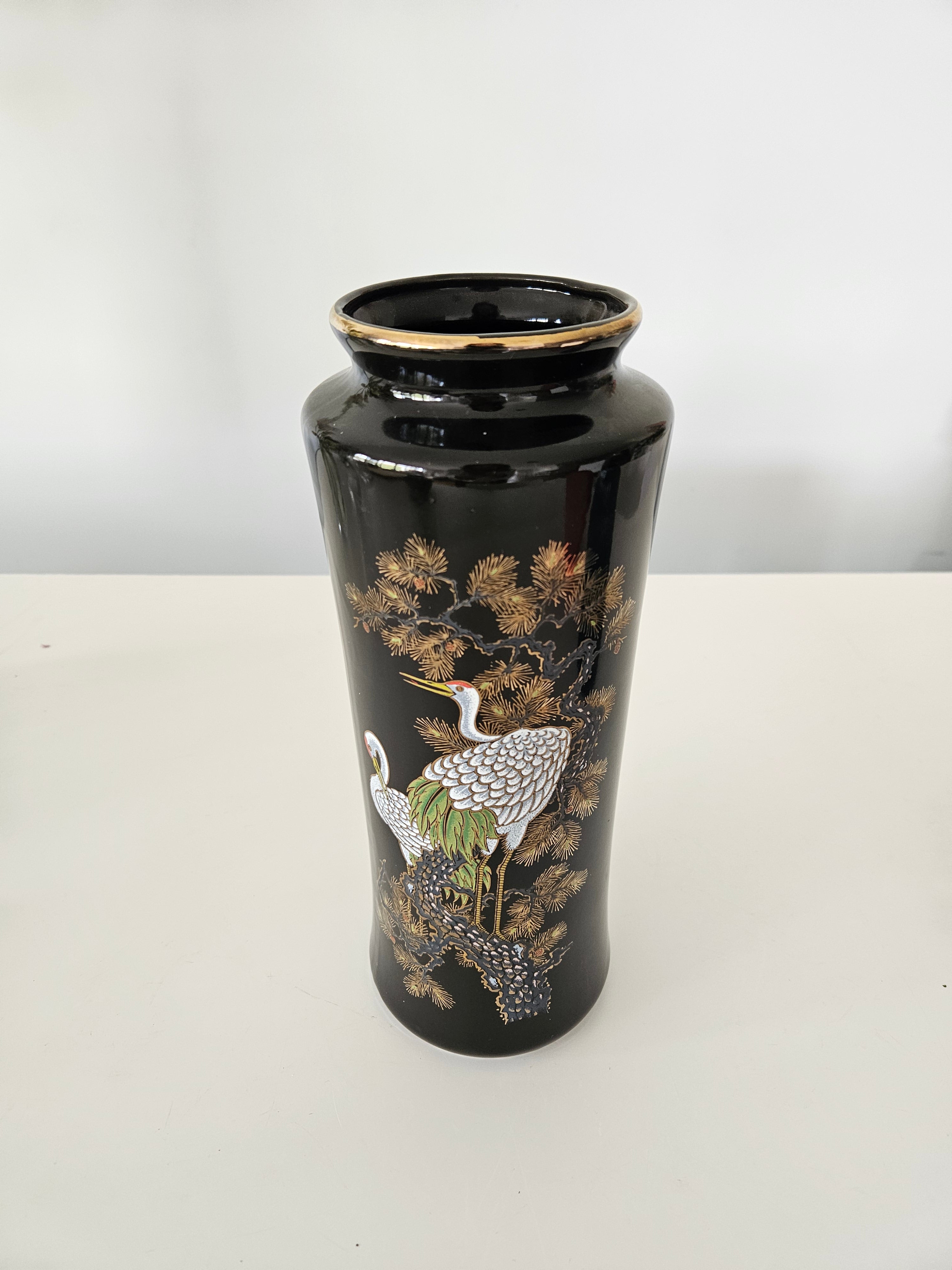 Decorative black vase with bird design on a white background