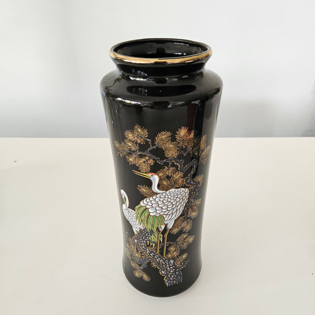 Decorative black vase with bird design on a white background