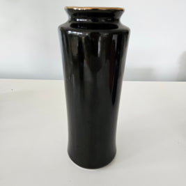 Back of a black ceramic vase with a gold rim on a white background