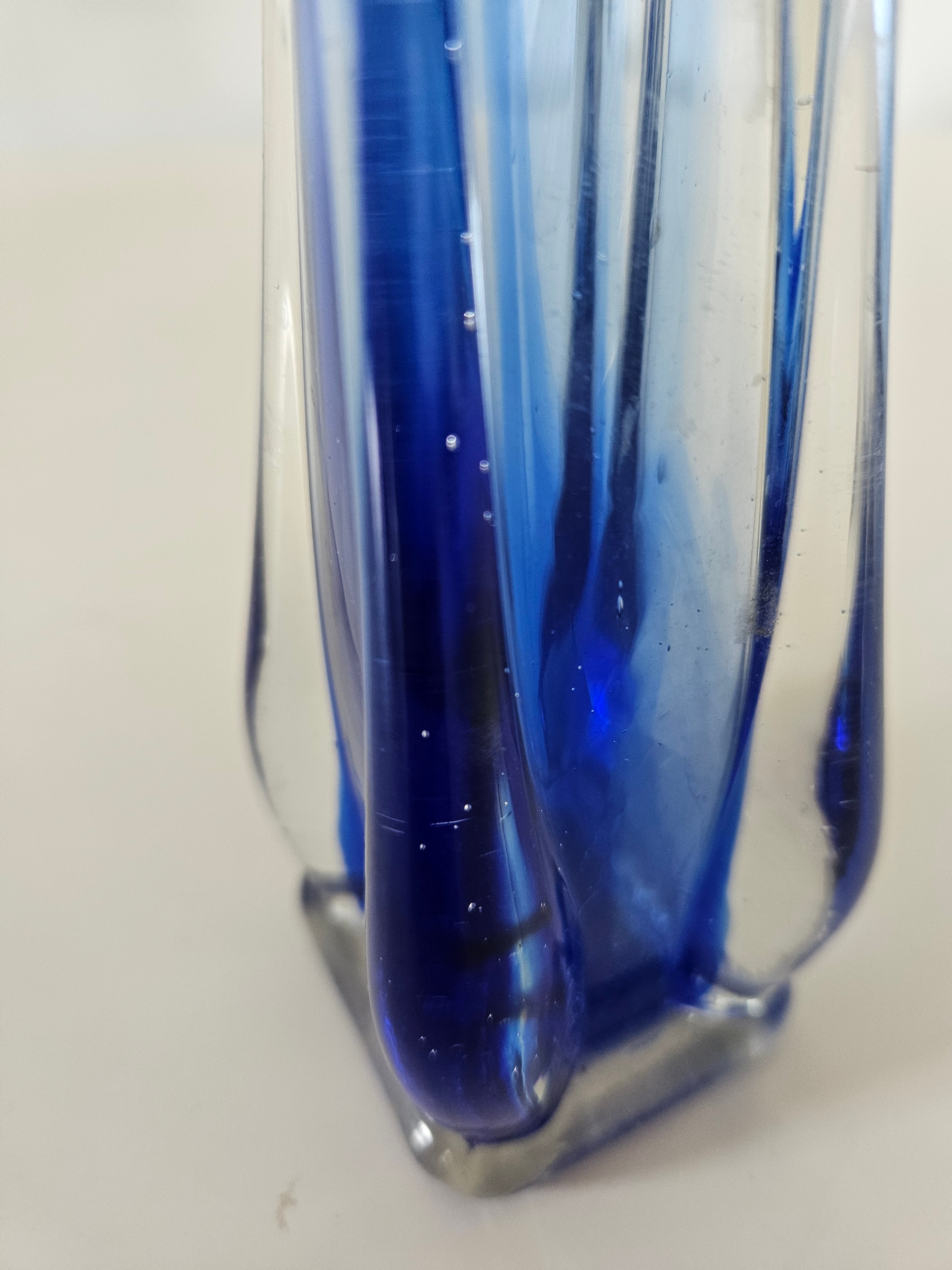 Close-up of bubbles on a blue glass vase on a white background