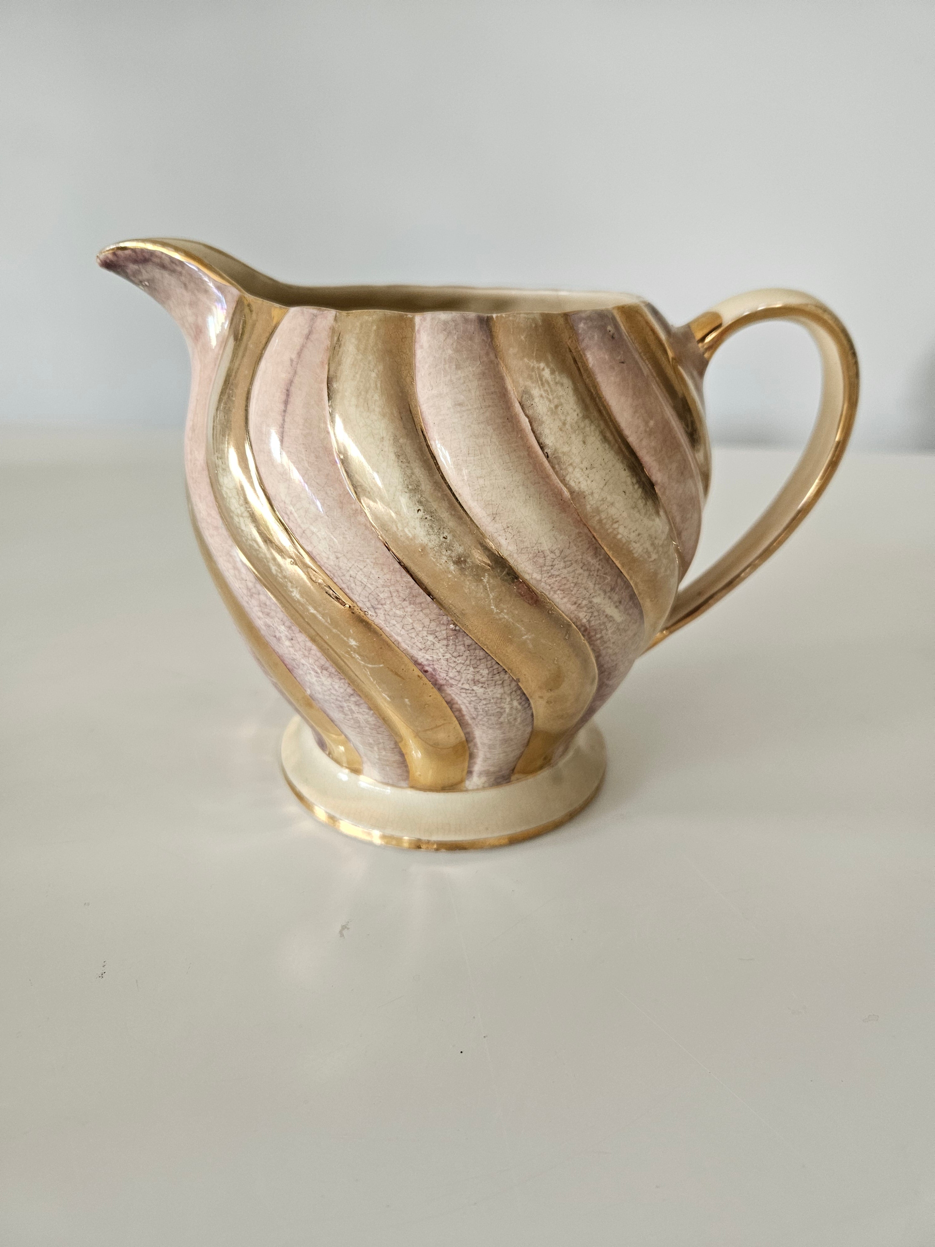 Decorative gold and purple teapot on a white background