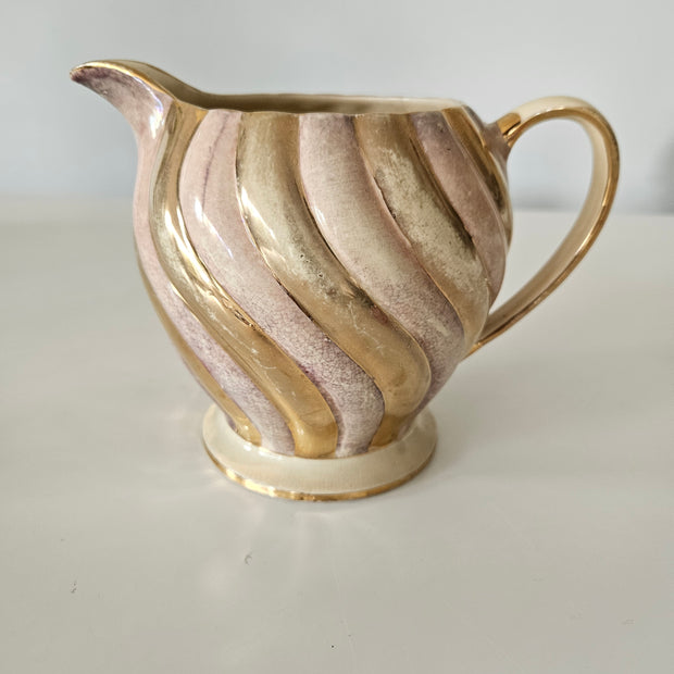 Decorative gold and purple teapot on a white background