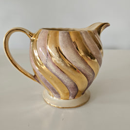 Gold and pink decorative teapot on a white background