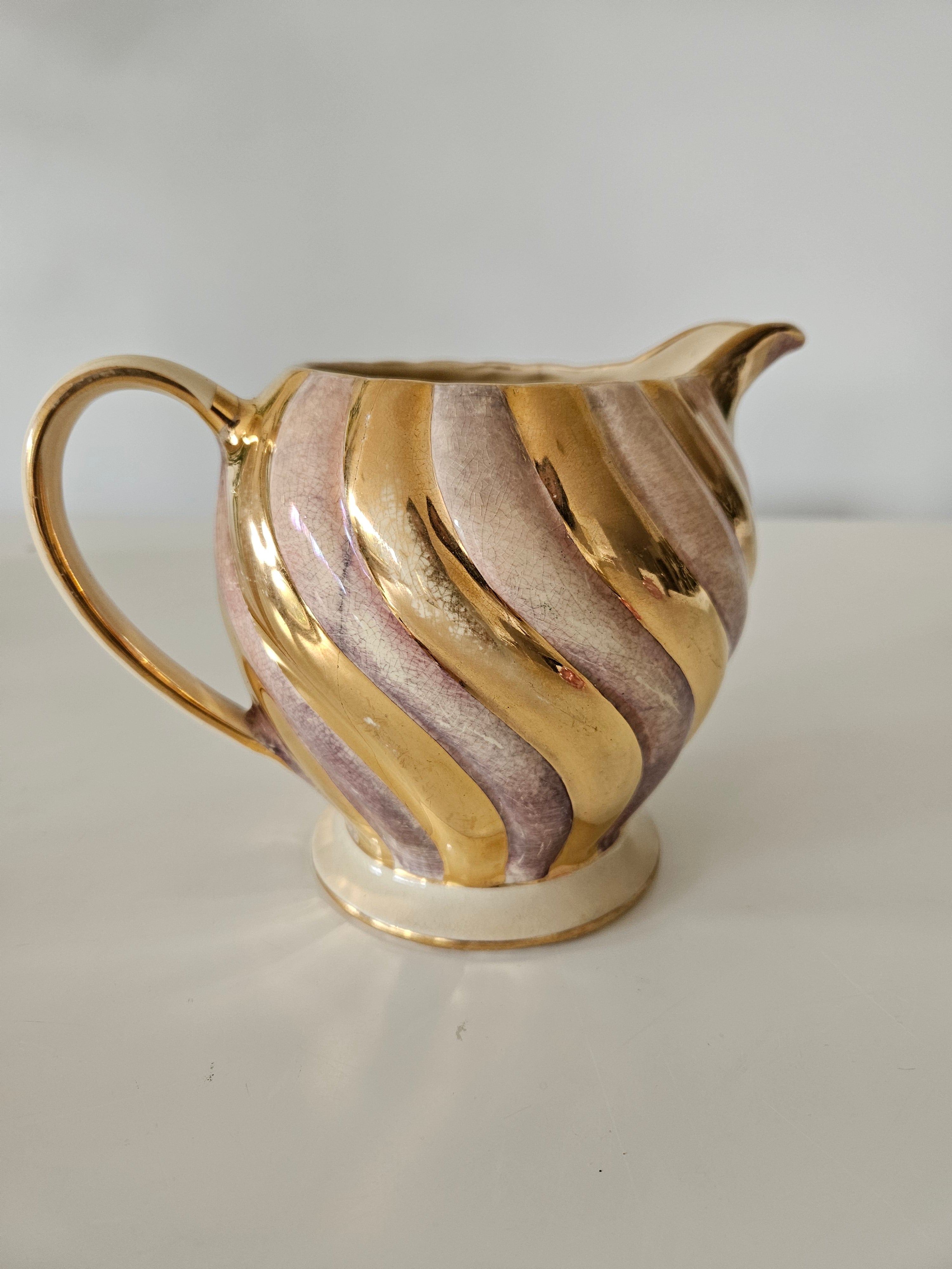 Gold and pink decorative teapot on a white background