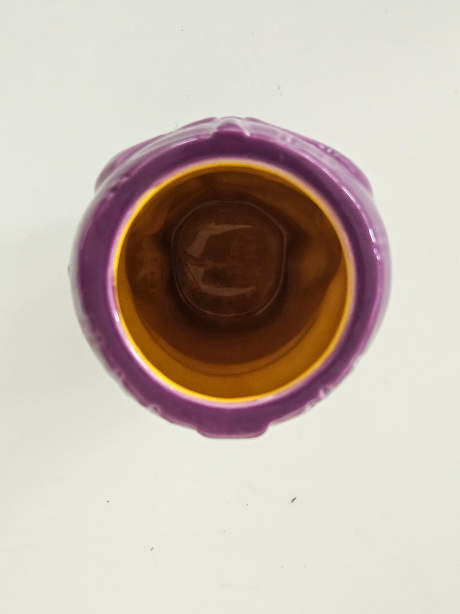 Top view of a purple ceramic vase with a brown interior on a white background