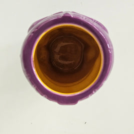 Top view of a purple ceramic vase with a brown interior on a white background