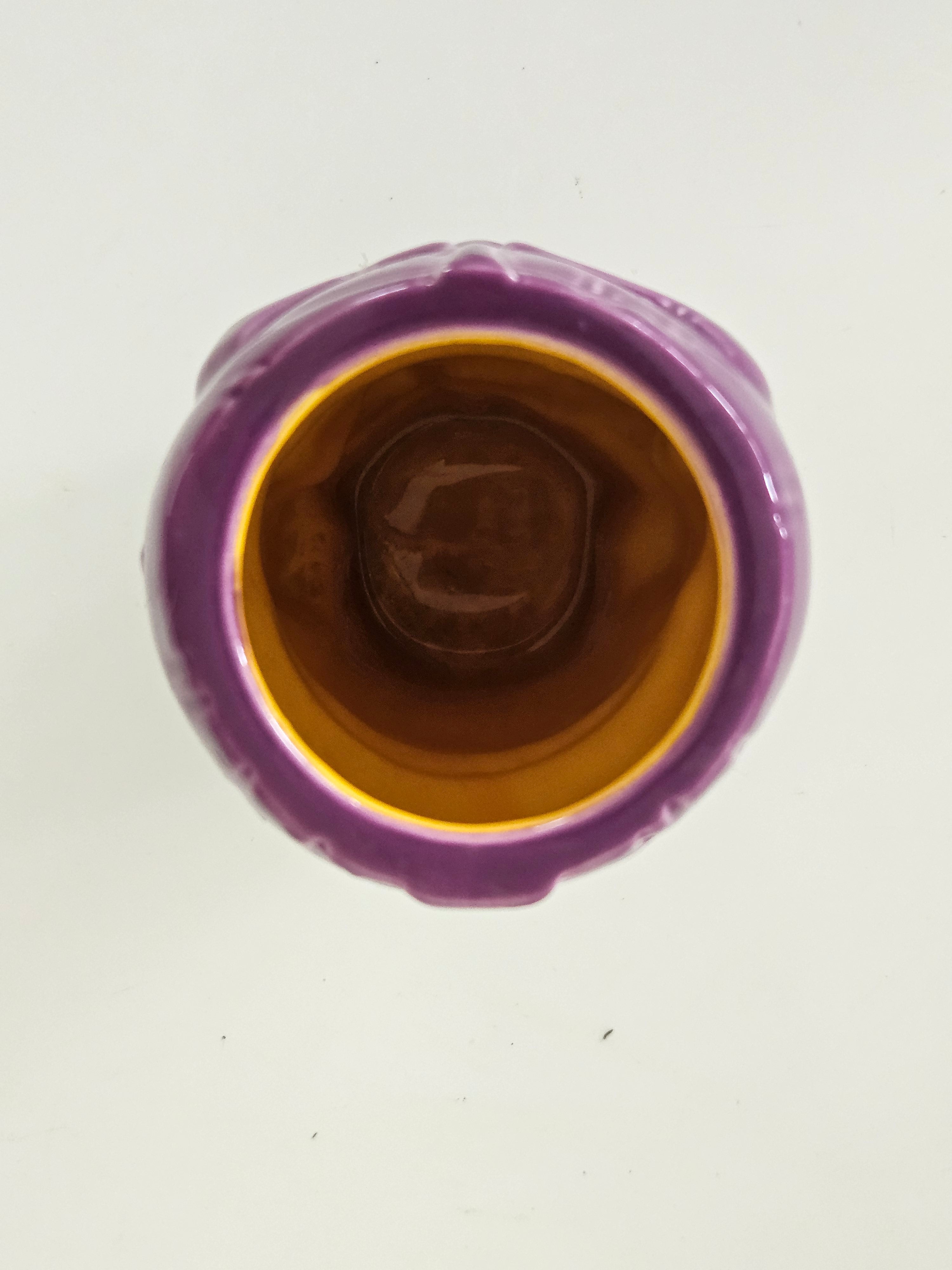 Top view of a purple ceramic vase with a brown interior on a white background