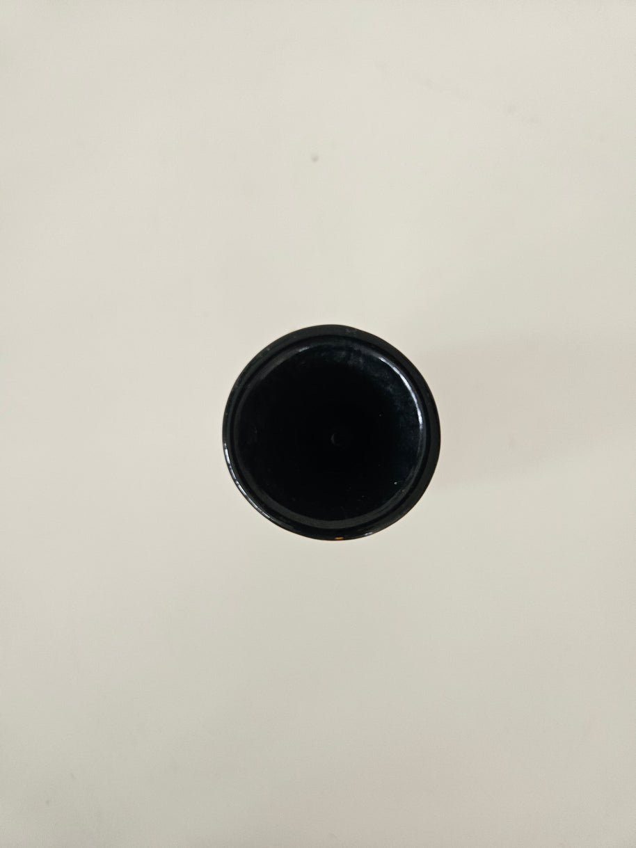 Top down view of a black vase on a white background