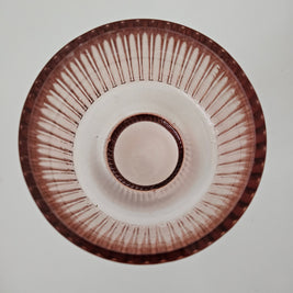 Top down view of a peach pink glass vase on a white background