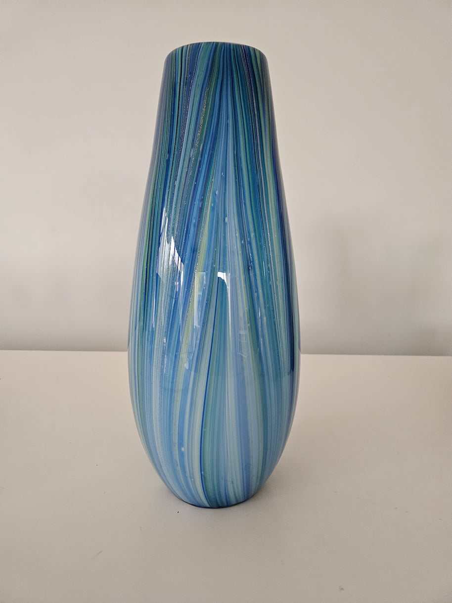Blue and green striped sparkling glass vase on a white background