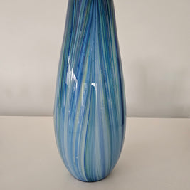 Blue and green striped sparkling glass vase on a white background