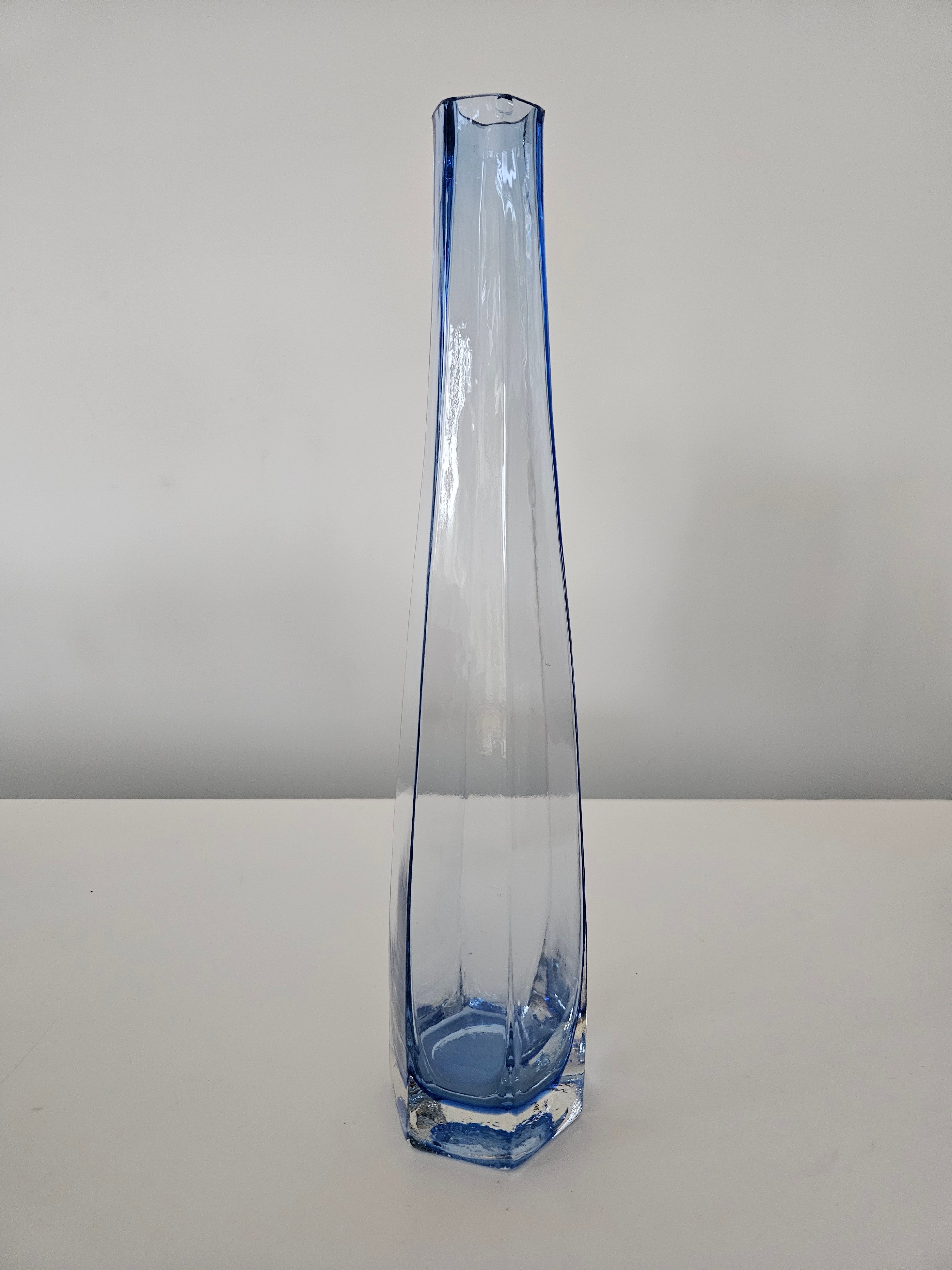 Clear glass vase with blue accent on a white background