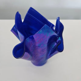Side view of a blue and purple handkerchief glass vase on a white background