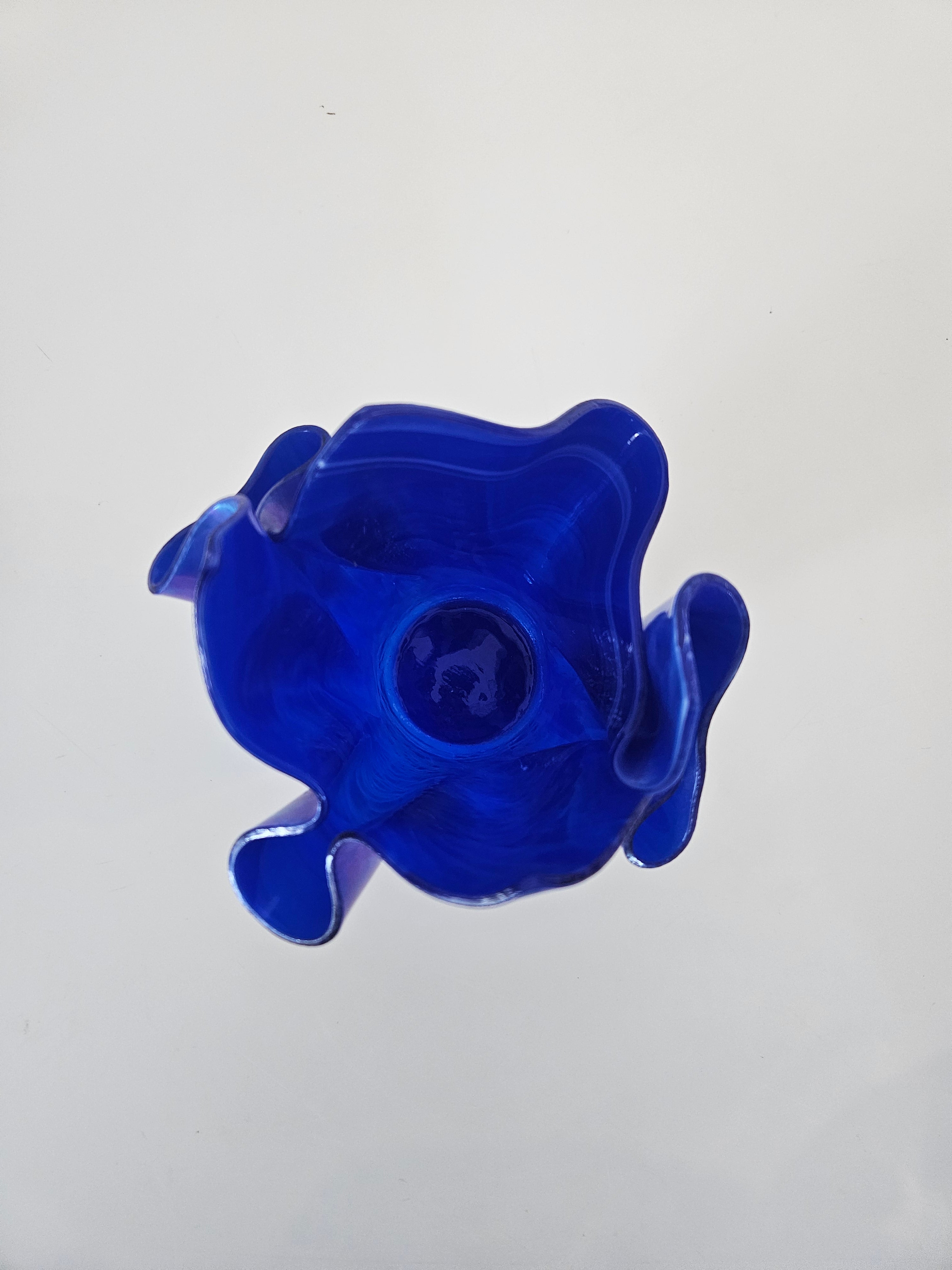 Top down view of a blue glass handkerchief vase