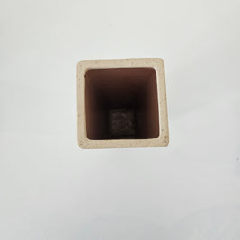 Top down view of a white square stone vase on a white background
