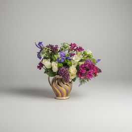 Bouquet of flowers in a decorative gold and lilac vase on a grey background