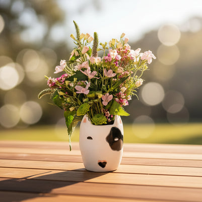 Bouquet of flowers against a white wall with a decorative mask.