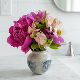 Floral arrangement on a marble benchtop in a bathroom
