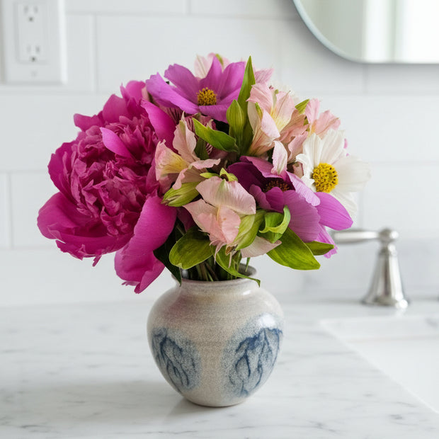 Floral arrangement on a marble benchtop in a bathroom