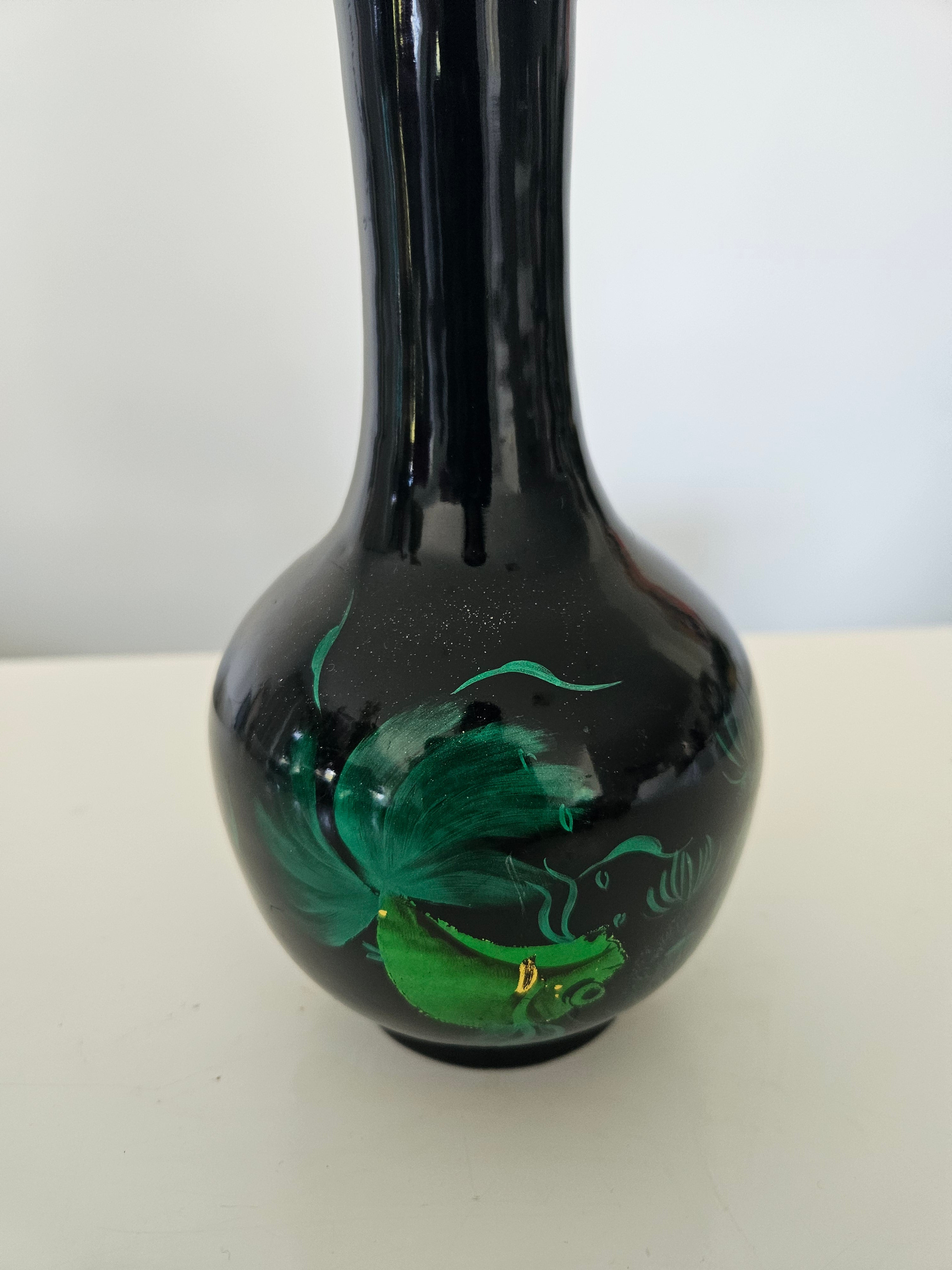 Black glass pipe with green designs on a white background