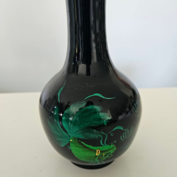 Black glass pipe with green designs on a white background