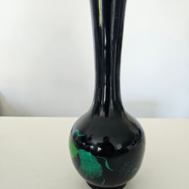Black ceramic vase with green interior on a white background